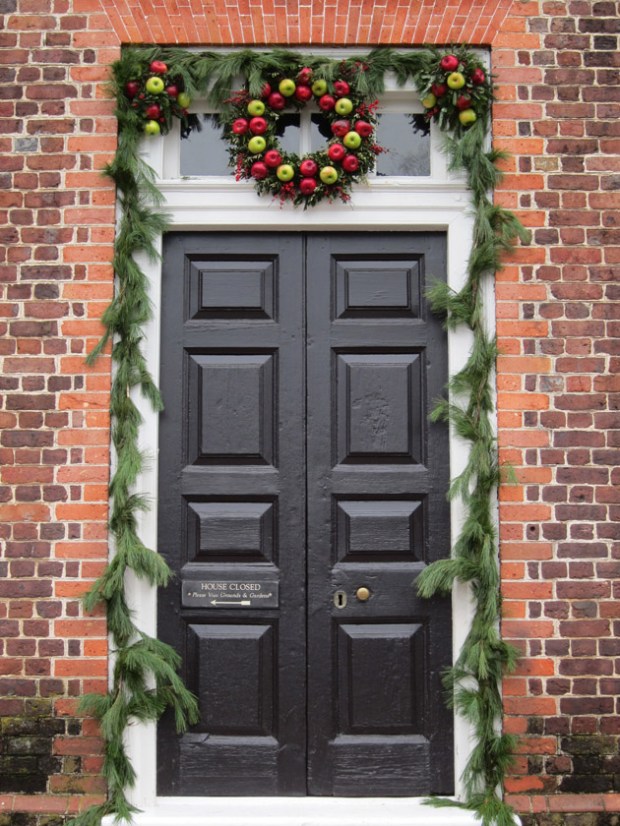 A festive door decorated with apples.